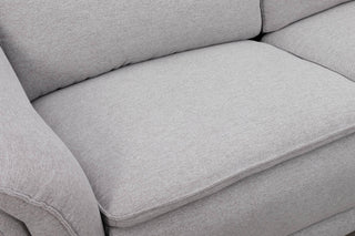Close-up of a gray sofa with visible texture and stitching.