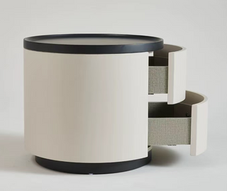 round bedside table with drawer with a black top and base on a white background
