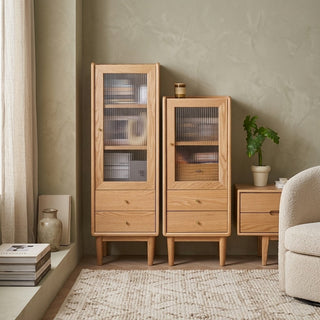 slim cabinets in a room with a plant and books.
