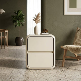 white bedside table in a modern room with a plant and chair.